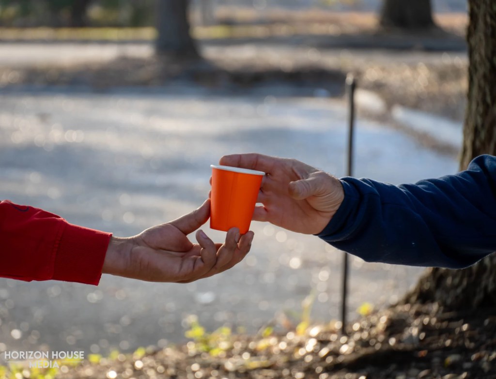 Volunteer handing water to a runner at the Lakewood 5K
